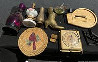 Full lot arrangement showing all items including clock, brass boot, glass lamp, candle holder, candy dish, cheese cutter, cardinal mat, and shelf brackets
