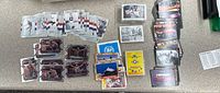 Wide layout of various trading cards including Olympic cards, military aircraft, and other themes spread on the floor