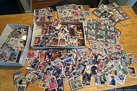 Wide view of the sports cards spread and boxed on table.