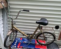Full side view of vintage Workman folding bicycle showing frame, wheels, handlebars, saddle, and rear rack.