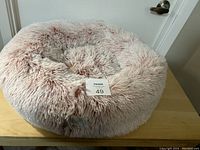 Top view of the pink plush animal bed showing the shaggy texture and circular shape.