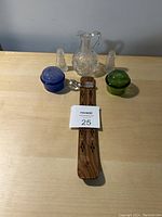 Photo of wooden incense holder with glass cruet, two small glass shakers, and two small colored glass jars on wood surface
