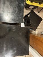 Top view of two black wooden end tables showing rectangular tops and surface wear.