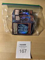 Plastic bag containing approximately 20 first edition holographic Yu-Gi-Oh! cards, showing the front art of some cards clearly with a holographic shine.