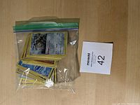 Plastic zip-lock bag containing multiple Pokemon trading cards stacked together, showing mostly the back and some front holo cards.