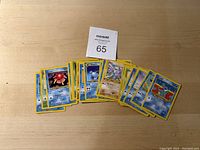 Photo of assorted 1st generation Pokémon cards spread out on a flat surface, showing front faces of multiple cards.