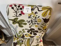 Front view of floral upholstered dining chair showing vivid multi-color floral fabric and shape.