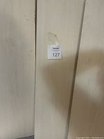 Photo of a plain wooden bookshelf showing a MaxSold auction tag