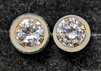 Close-up of front view of the pair of 14K gold cubic zirconia stud earrings showing the prong settings and round CZ stones.