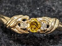 Top-down view of ring showing central yellow lab-grown diamond and side white diamonds in braided band.
