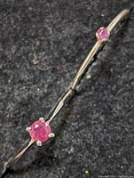 Close-up front angle of the larger ruby sterling silver ring showing the four prong setting and ruby color.