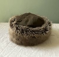 Front view of the Barbour winter hat showing waxed cotton top and faux fur trim.