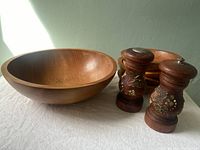 Photo of large wooden salad bowl alongside four smaller bowls and salt and pepper shakers.