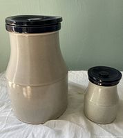 Front view of the pair of Denby Potpourri Blue stoneware cannisters showing cream speckled body and dark blue lids.