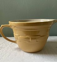 Side view of the yellow batter bowl showing handle and embossed exterior design.