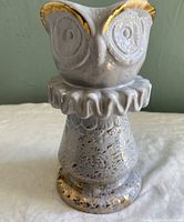 Front view of off-white owl vase with gold accents, showing detailed owl face and textured chess piece style base