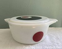 Side view of white Pyrex casserole dish with red circle decoration and lid on top