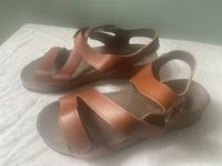 Side view of brown leather Roemer by Romika sandal showing three straps over foot and ankle strap with velcro closure.