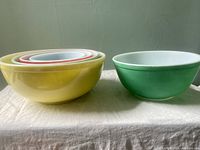 Set of 4 primary color Pyrex nesting bowls with one separate green bowl showing different sizes and nesting.