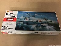 Photo shows the unopened rectangular box of the Hasegawa Lockheed F-104J Starfighter model kit with box art of the aircraft flying.