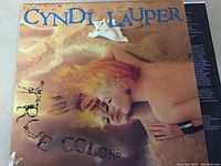 Photo of front cover of Cyndi Lauper's True Colors vinyl record. Shows colorful image of artist with album title.