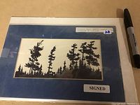 Photo showing framed original art titled "October Wind (1974)" by artist J.N.W.W. with visible signature and label.