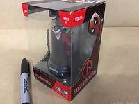 Venompool figure visible through clear display box with Series 5 and Deadpool branding, unopened packaging with marker for size reference.