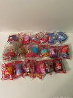 Twenty Littlest Pet Shop toys sealed in original McDonald's packaging, various animal designs and colors visible.