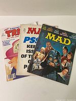 Lot of three magazines including Mad Magazine No. 106 from 1978 Star Wars Edition, a Mad Magazine with PSY text on cover, and a Trash Magazine.