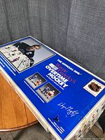 Photo showing the original box of Wayne Gretzky's NHL Overtime Hockey game, blue background, Wayne Gretzky image and signature, with NHL logos.