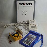 Photo showing all items in the lot: Duracell battery charger, nexXTECH battery tester, and blue phone protector pouch.