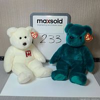 Front view of the two Ty Beanie Buddy bears sitting against a wall with a MaxSold sign showing lot number 233.