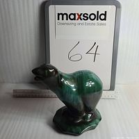 Front view of the green glazed ceramic polarbear figurine with a ruler in the background for scale