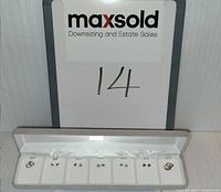 Overall image of children's sterling silver earring set in display box, showing all 7 pairs of earrings arranged in slots.