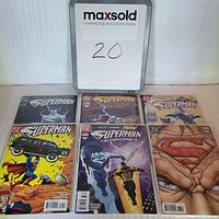 Photo of all six Superman comics laid out flat, showcasing varied cover art and sealed in protective sleeves.
