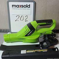 Earthwise cordless leaf blower with battery, charger, and two black extension nozzles laid out on white surface