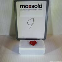 Pair of hematite sterling silver earrings displayed on a raised white platform with maxsold branding in background.