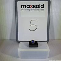 Front view of the labradorite ring on a black foam display with white backdrop showing MaxSold sign and lot number 5.