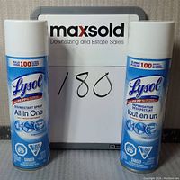 Front view of two Lysol disinfectant spray cans side by side with MaxSold sign behind them labeled 180