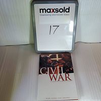 Photo of the graphic novel with a small whiteboard indicating lot 17