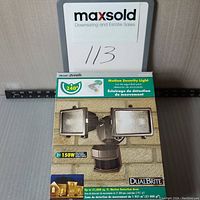 Photo of the DualBrite motion security light in original packaging showing front and side view with product details.