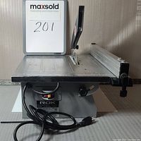 Full view of the Rok 7-inch tile saw showing the cutting table, blade, and power cord.