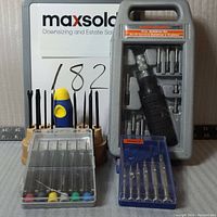 Lot of four screwdriver sets including multibit, precision and small Armaco sets on a white background with measuring scale.