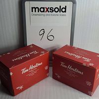 Two red Tim Hortons holiday mug boxes shown side by side with maxsold sign behind