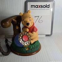 Front view of Winnie-The-Pooh vintage landline phone showing rotary dial and part of handset.