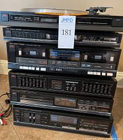 Stacked Fisher stereo components including turntable, cassette deck, equalizer, CD player, and amplifier all in a dark finish, various control buttons and displays visible.