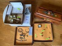 Overview of two trays showing gold and sterling jewelry, assorted watches and wooden box