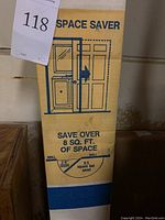 Close-up of packaging with 'Space Saver' branding and graphic showing pocket door saving space compared to a swinging door.