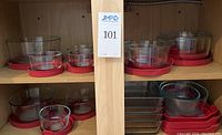 Shelved glass storage containers with red lids, various sizes visible