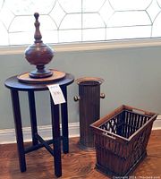 Full lot showing side table, decorative urn on table, metal umbrella stand, and wood magazine rack on floor near wall.